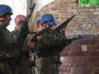 The Shkval (Squall) Battalion servicemen are holding rifles during drills in Ukraine, on July 26, 2024. Former prisoners who volunteered to...