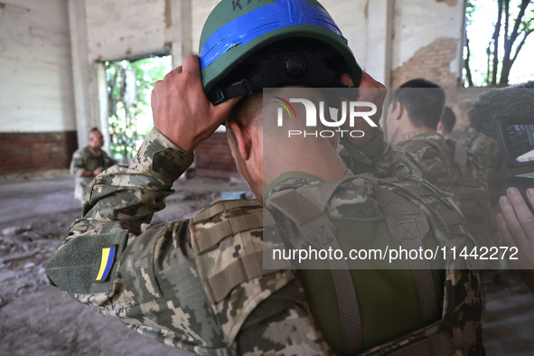 A Shkval (Squall) Battalion serviceman is holding a helmet during drills in Ukraine, on July 26, 2024. Former prisoners who volunteered to d...