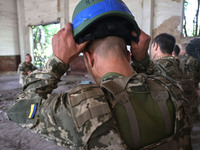 A Shkval (Squall) Battalion serviceman is holding a helmet during drills in Ukraine, on July 26, 2024. Former prisoners who volunteered to d...