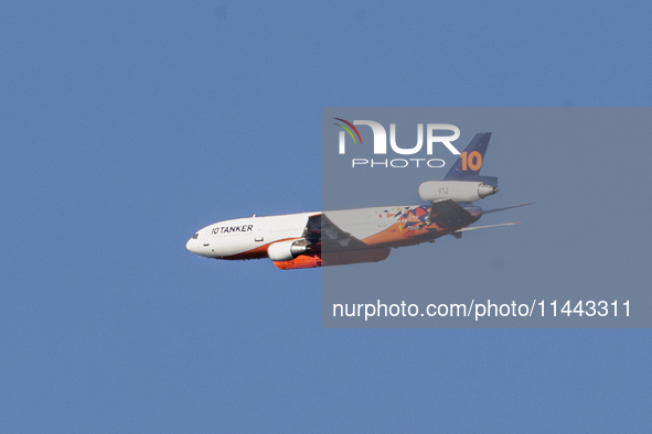 Tanker 912, a DC-10 Air Tanker used to fight fires, is flying past North Table Mountain Ecological Reserve, near the Park Fire, in Oroville,...