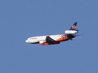 Tanker 912, a DC-10 Air Tanker used to fight fires, is flying past North Table Mountain Ecological Reserve, near the Park Fire, in Oroville,...