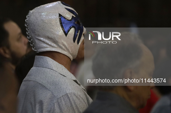 Atlantis, a wrestler, is observing the relics of St. Jude Thaddeus while wearing a mask inside the Metropolitan Cathedral in Mexico City, Me...