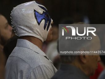 Atlantis, a wrestler, is observing the relics of St. Jude Thaddeus while wearing a mask inside the Metropolitan Cathedral in Mexico City, Me...