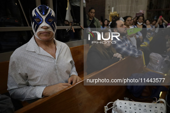 Atlantis, a wrestler, is observing the relics of St. Jude Thaddeus while wearing a mask inside the Metropolitan Cathedral in Mexico City, Me...