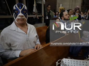 Atlantis, a wrestler, is observing the relics of St. Jude Thaddeus while wearing a mask inside the Metropolitan Cathedral in Mexico City, Me...