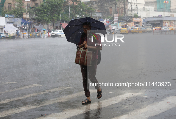 A man is walking on a road during heavy monsoon rain in Kolkata, eastern India, on July 30, 2024. 