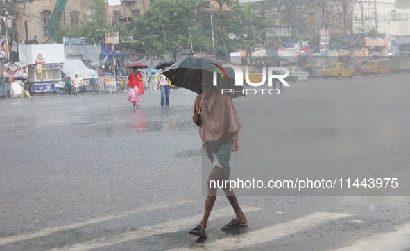 A man is walking on a road during heavy monsoon rain in Kolkata, eastern India, on July 30, 2024. 