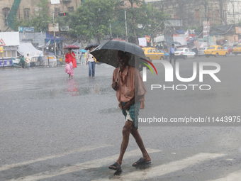 A man is walking on a road during heavy monsoon rain in Kolkata, eastern India, on July 30, 2024. (