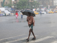 A man is walking on a road during heavy monsoon rain in Kolkata, eastern India, on July 30, 2024. (