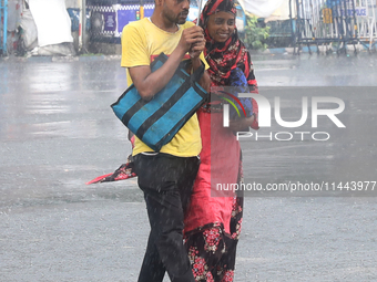 Commuters are crossing a road during heavy monsoon rain in Kolkata, eastern India, on July 30, 2024 (