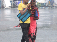 Commuters are crossing a road during heavy monsoon rain in Kolkata, eastern India, on July 30, 2024 (