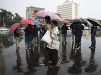 A man is holding an umbrella as he is crossing a road during monsoon rain in Kolkata, eastern India, on July 30, 2024 (