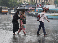 Commuters are crossing a road during heavy monsoon rain in Kolkata, eastern India, on July 30, 2024 (