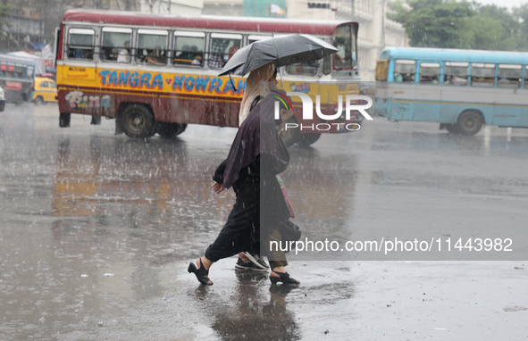 Women are crossing a road during heavy monsoon rain in Kolkata, India, on July 30, 2024. 