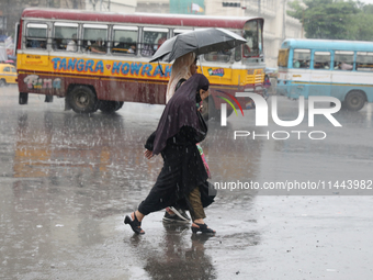 Women are crossing a road during heavy monsoon rain in Kolkata, India, on July 30, 2024. (