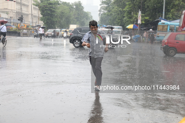 A man is crossing a road during heavy monsoon rain in Kolkata, India, on July 30, 2024. 