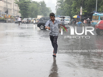 A man is crossing a road during heavy monsoon rain in Kolkata, India, on July 30, 2024. (