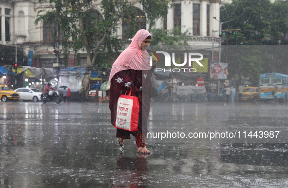 A woman is walking on a road during monsoon rain in Kolkata, eastern India, on July 30, 2024. 