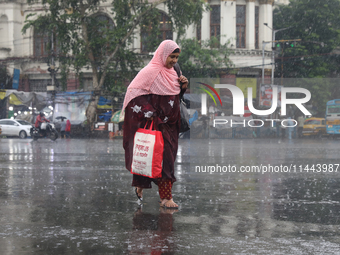 A woman is walking on a road during monsoon rain in Kolkata, eastern India, on July 30, 2024. (