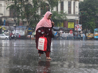 A woman is walking on a road during monsoon rain in Kolkata, eastern India, on July 30, 2024. (