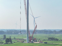 Workers are installing wind power equipment at Henggou village in Huai'an city, East China's Jiangsu province, on July 30, 2024. (