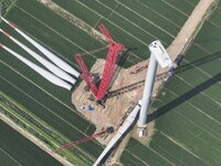 Workers are installing wind power equipment at Henggou village in Huai'an city, East China's Jiangsu province, on July 30, 2024. (