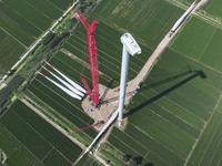 Workers are installing wind power equipment at Henggou village in Huai'an city, East China's Jiangsu province, on July 30, 2024. (