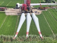 Workers are installing wind power equipment at Henggou village in Huai'an city, East China's Jiangsu province, on July 30, 2024. (