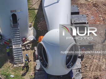 Workers are installing wind power equipment at Henggou village in Huai'an city, East China's Jiangsu province, on July 30, 2024. (