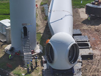 Workers are installing wind power equipment at Henggou village in Huai'an city, East China's Jiangsu province, on July 30, 2024. (