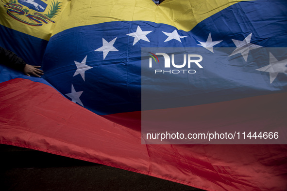 Opponents of Venezuelan President Nicolas Maduro are displaying a Venezuelan flag during a rally called by presidential candidate Edmundo Go...