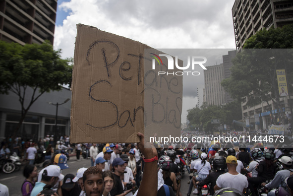 Opponents of Venezuelan President Nicolas Maduro are displaying a Venezuelan flag during a rally called by presidential candidate Edmundo Go...