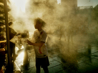 People are cooling off and enjoying a water spray as temperatures rise in Paris, France, on July 30, 2024, during the Paris 2024 Olympic Gam...