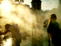 People are cooling off and enjoying a water spray as temperatures rise in Paris, France, on July 30, 2024, during the Paris 2024 Olympic Gam...