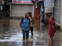 Residents of Kathmandu are wading through the floodwater along the embankment of the Bagmati River flowing through the capital after incessa...