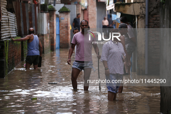 Residents of Kathmandu are wading through the floodwater along the embankment of the Bagmati River flowing through the capital after incessa...