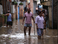 Residents of Kathmandu are wading through the floodwater along the embankment of the Bagmati River flowing through the capital after incessa...