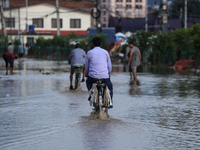 Residents of Kathmandu are wading through the floodwater along the embankment of the Bagmati River flowing through the capital after incessa...