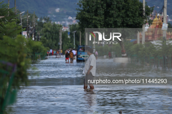 Residents of Kathmandu are wading through the floodwater along the embankment of the Bagmati River flowing through the capital after incessa...