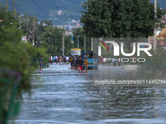 Residents of Kathmandu are wading through the floodwater along the embankment of the Bagmati River flowing through the capital after incessa...