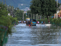 Residents of Kathmandu are wading through the floodwater along the embankment of the Bagmati River flowing through the capital after incessa...