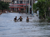 Residents of Kathmandu are wading through the floodwater along the embankment of the Bagmati River flowing through the capital after incessa...