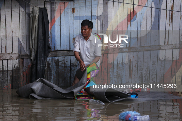 Residents of Kathmandu are wading through the floodwater along the embankment of the Bagmati River flowing through the capital after incessa...