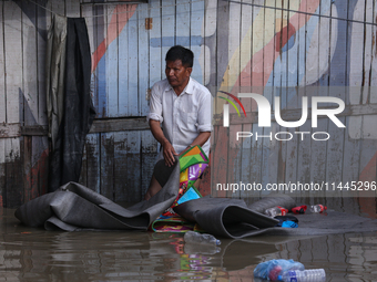 Residents of Kathmandu are wading through the floodwater along the embankment of the Bagmati River flowing through the capital after incessa...