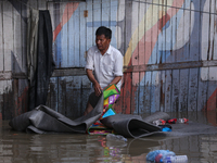 Residents of Kathmandu are wading through the floodwater along the embankment of the Bagmati River flowing through the capital after incessa...