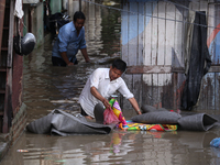 Residents of Kathmandu are wading through the floodwater along the embankment of the Bagmati River flowing through the capital after incessa...