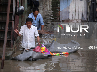 Residents of Kathmandu are wading through the floodwater along the embankment of the Bagmati River flowing through the capital after incessa...