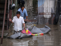 Residents of Kathmandu are wading through the floodwater along the embankment of the Bagmati River flowing through the capital after incessa...