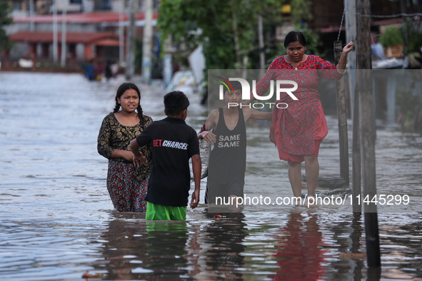 Residents of Kathmandu are wading through the floodwater along the embankment of the Bagmati River flowing through the capital after incessa...