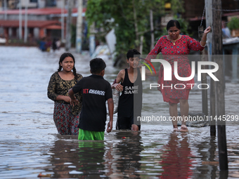 Residents of Kathmandu are wading through the floodwater along the embankment of the Bagmati River flowing through the capital after incessa...